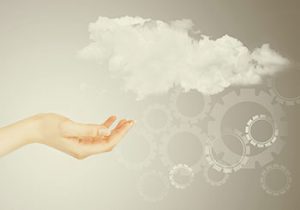 A hand reaching towards clouds with digital gears, symbolizing cloud computing.