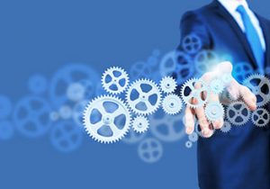 A man in a suit touching digital gears, representing managed services.
