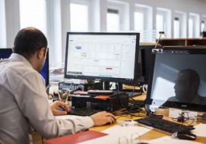 A man sitting in front of his computer while receiving remote IT services & support.