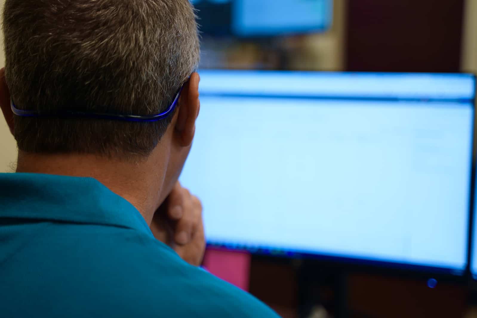 Blue Light IT team member inspecting code on a computer monitor