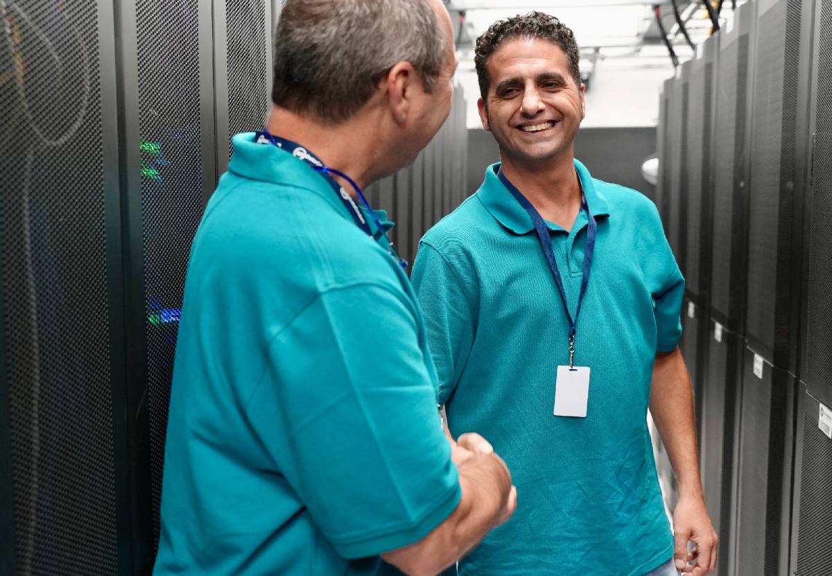 Two members of Blue Light IT shaking hands after implementing a cybersecurity solution for a client.