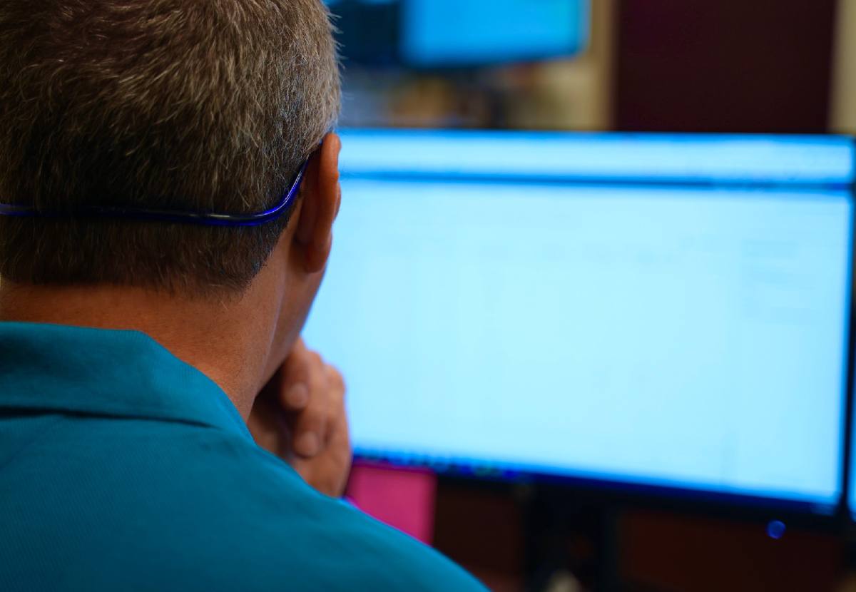 Blue Light IT team member inspecting code on a computer monitor