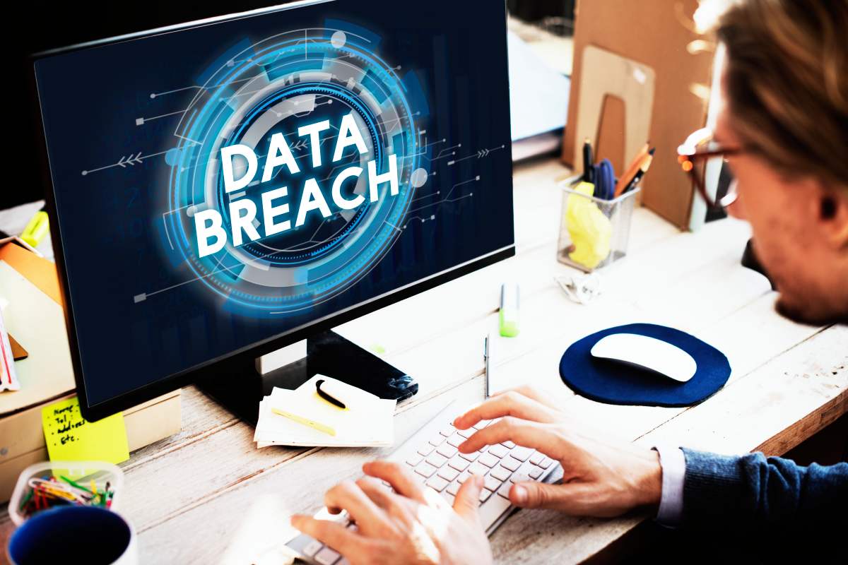 Computer monitor displaying a graphic reading "Data Breach" and a technician doing data backup in Delray Beach